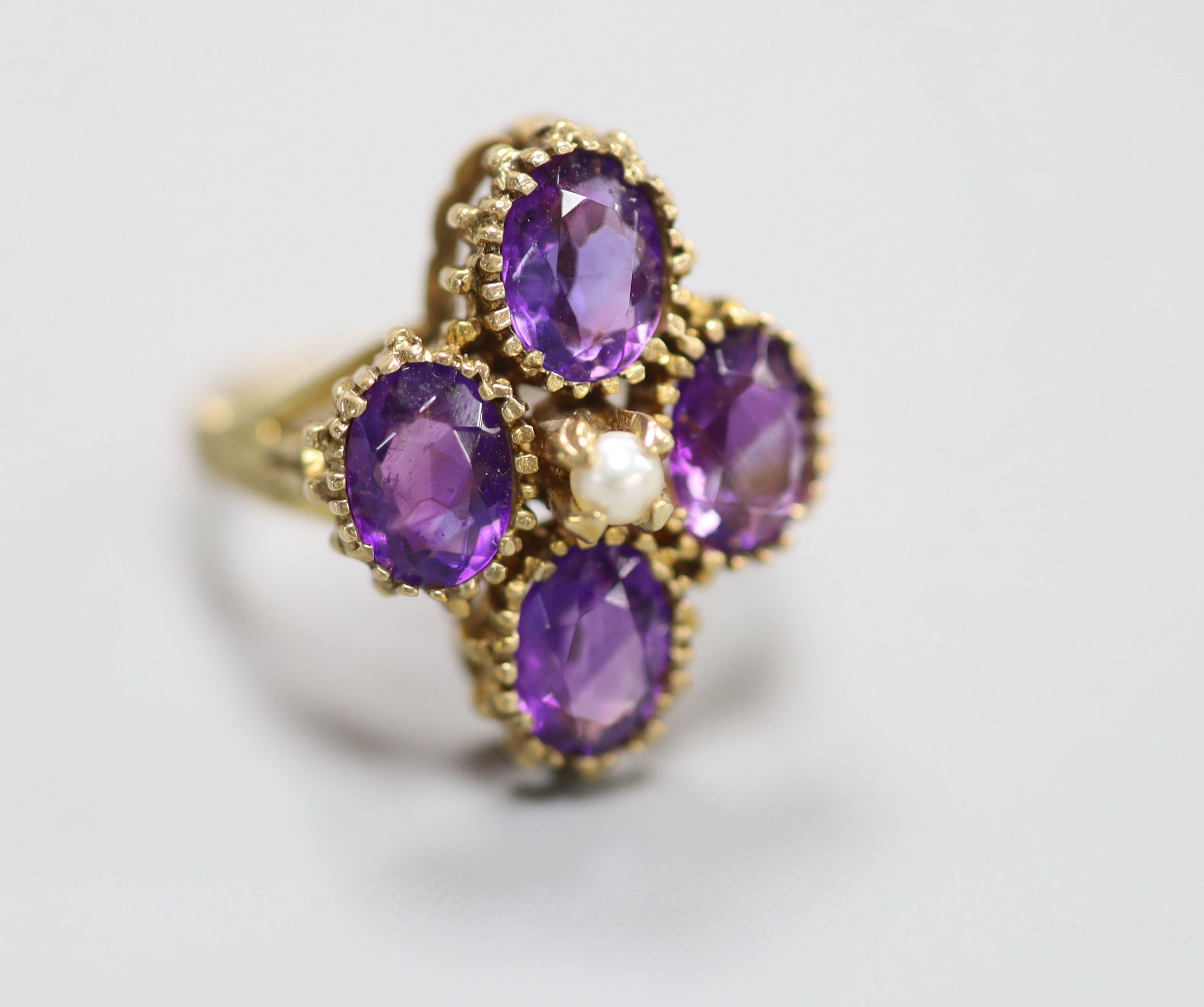 Three assorted 9ct and amethyst set dress rings, including amethyst and diamond and amethyst and seed pearl and one 9ct and amethyst paste ring.